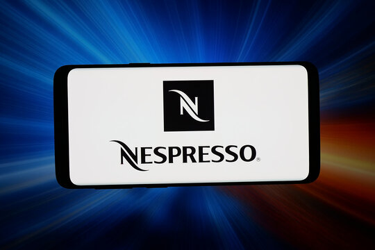 Stuttgart, Germany - 04-16-2026: In this photo illustration, the logo of coffee capsule company Nestle Nespresso S.A. is displayed on a smartphone in front of abstract background on computer screen.