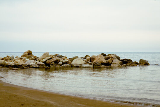 Tranquil Zapalo Beach with rock breakwater and sandy shore in Limassol, Cyprus