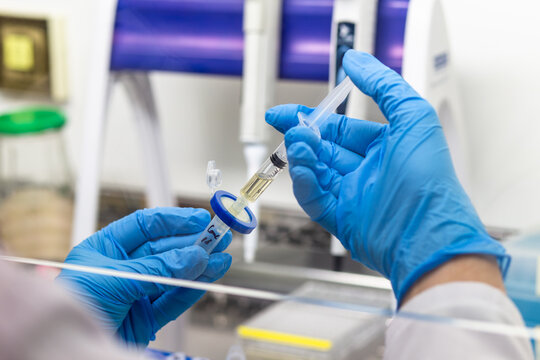 The scientist filters the solution from the syringe through a disc filter into a test tube, separating the liquid from the particles.