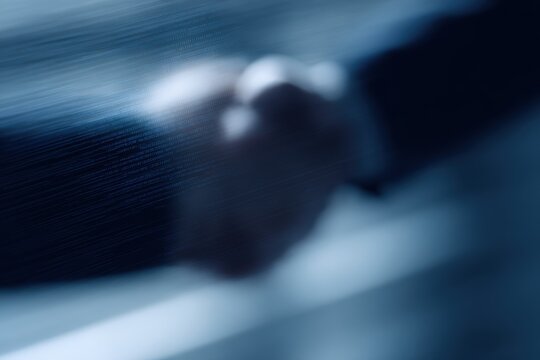 Realistic shot of a handshake between two professionals reflected in a digital screen with code, trusted partnership