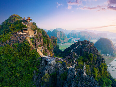Scenic view of mua caves in Ninh Binh with lush greenery and towering limestone hills at sunrise