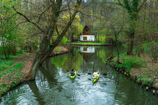Traditional wooden house and kayak rental station along a calm water canal in the Spreewald Biosphere Reserve, Lehde, Brandenburg, Germany.