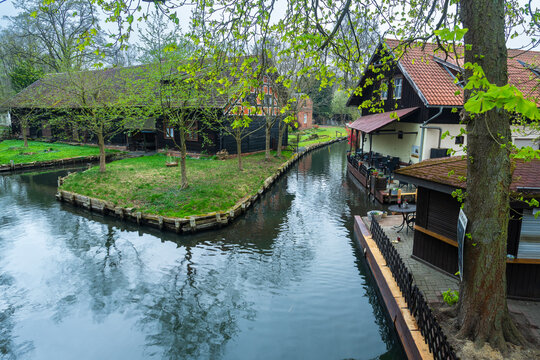 Traditional wooden house and kayak rental station along a calm water canal in the Spreewald Biosphere Reserve, Lehde, Brandenburg, Germany.