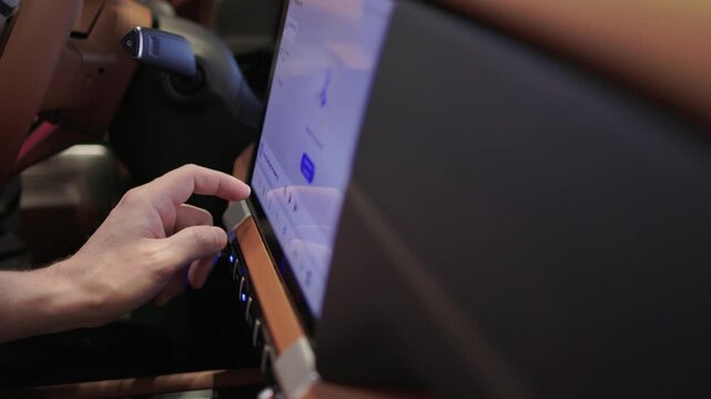 Touch interface controls vehicle features. Driver uses touchscreen to manage car functions. Driver taps icons on dashboard touchscreen for media and climate adjustments