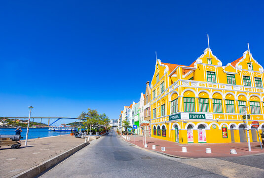 Willemctad, Curacao - 22.03.2026: Penha building with Dutch colonial architecture on the waterfront with Queen Juliana Bridge in Willemstad Curacao