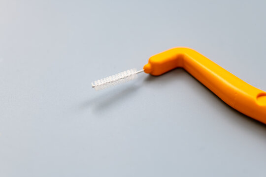 A macro close up of an angle interdental brush isolated on grey.