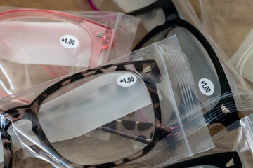 Fototapeta premium A closeup of plus one sight correction reading glasses in plastic packages.