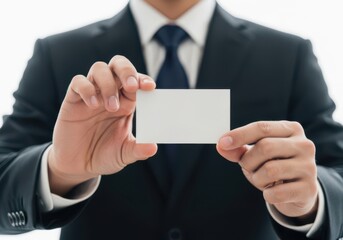 Fototapeta premium Businessman in suit holding a blank white business card for your design