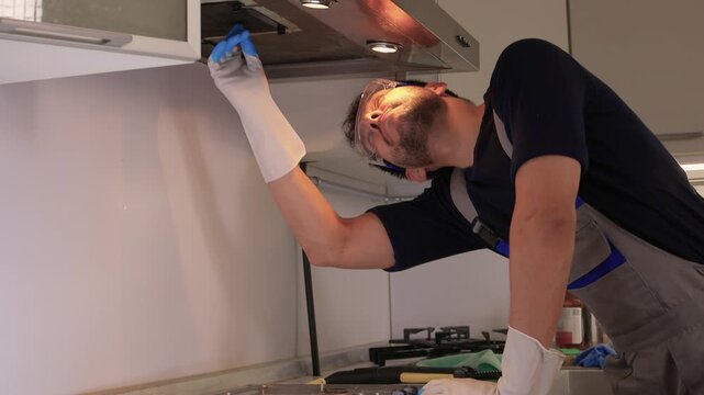 Professional technician ensures proper cleaning and safety measures. Trained technician performs detailed cleaning while maintaining safety in modern kitchen environment