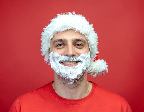 Man smiling wearing santa hat shaving cream beard