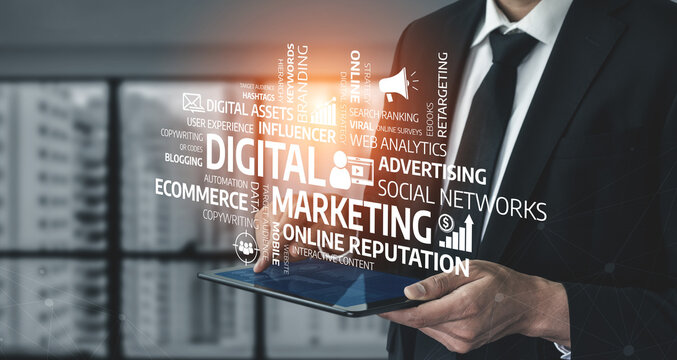 A businessman in a black suit holds a tablet displaying various digital marketing concepts, signifying the importance of online strategies and brand management in today business world. Tessel