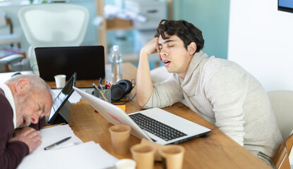 Fototapeta premium Tired male office workers having nap while sitting in his workplace