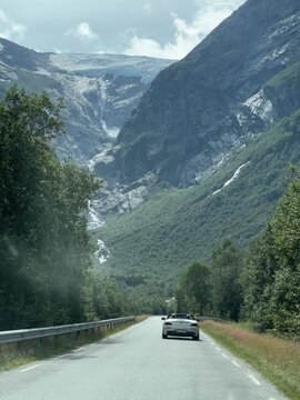 Convertible Sports Car Driving Through Mountain Valley in Stryn, Norway