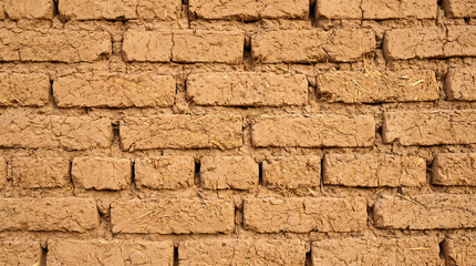 Obraz premium Stacked Sun-Dried Mud Brick Wall in Warm Earthen Tan with Straw Fibers