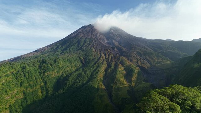 Aerial drone footage of the majestic Mount Merapi, surrounded by lush green forests and exotic lava flows, is Indonesia's most active volcano.