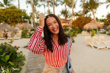 Naklejka premium Close portrait of smiling young woman in tropical resort setting