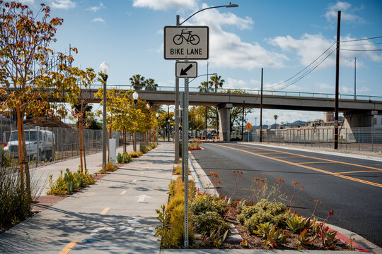 Dedicated bike lane with directional arrows and signage next to a road