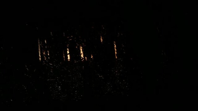 Water droplets cascade down a dark surface as brushes move in a car wash, creating a dynamic visual of cleaning action and water interaction in a commercial setting