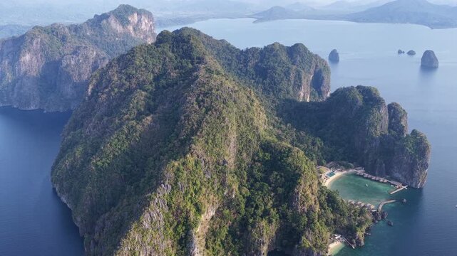 Lagen Island, a dramatic limestone island, rises in Bacuit Bay, El Nido. This area in the Philippines is a popular vacation destination due to its beautiful coral reefs, beaches, and hidden lagoons.