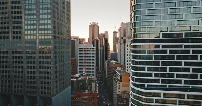 Modern cityscape drone flight. Sydney Central Business District modern skyscrapers and urban architecture at sunrise, with light reflecting on high building glass facades and city streets waking up