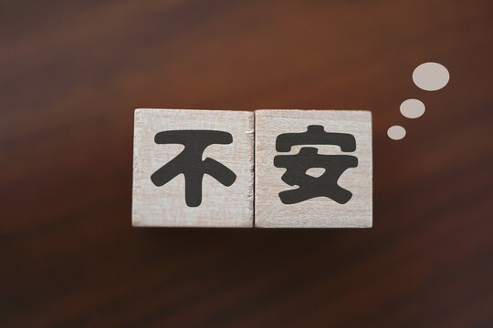 不安とストレスのイメージ。木製ブロック。茶色い背景。