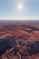 Fototapeta premium Aerial Red Desert Landscape With Sunlit Canyons and Distant Hills — 3D Rendering View