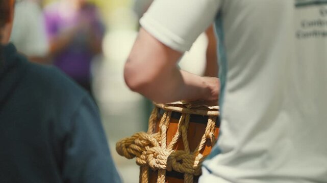 Capoeira musician playing atabaque drum during roda