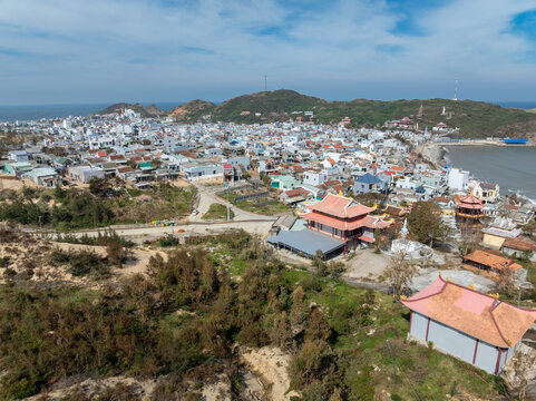 A large Buddha statue overlooks the coastal town of Nhon Ly, Quy Nhon, Binh Dinh, Vietnam. The serene statue stands watch over the city and the ocean.