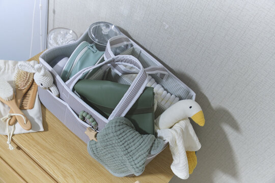 Baby care caddy filled with essential items for health and wellness on a chest of drawers