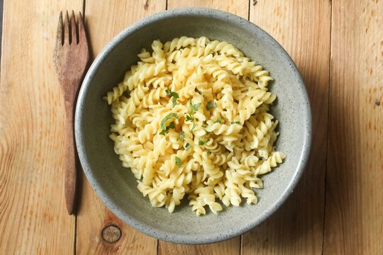 top view of a bowl of fusilli pasta on a wooden table