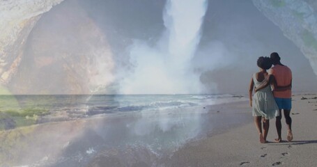 Naklejka premium Walking couple strolling on wet sand by sea, in sundress shirt, passing waterfall mist, copy space