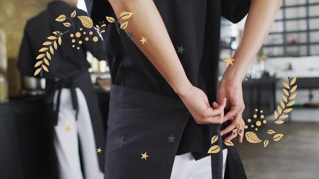 Male chef starting shift, tightening apron knot in kitchen while gold leaf stars overlaying hands