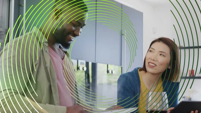 Woman pointing to tablet guiding man chopping veg for food, green ring overlay obscuring faces