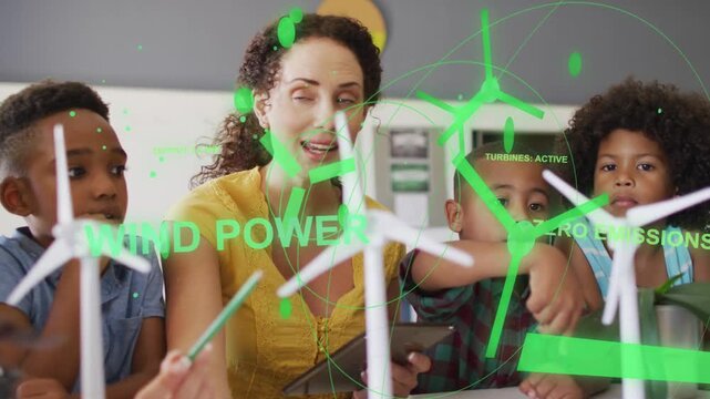 Teacher tapping tablet, guiding three boys spinning turbines as green overlays teaching wind energy
