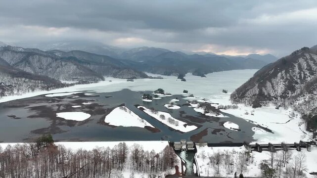 Aerial view of Akimoto Lake dam and spillway in winter snow, Fukushima Japan