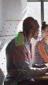 Vertical video: Man leaning toward peer after comment, tech HUD charts sliding and obscuring faces