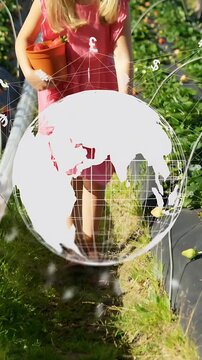 Vertical video: Child stepping, causing fintech globe crossing frame while picking fruits into pot