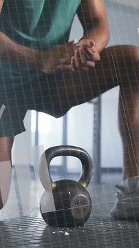 Vertical video: Fitness lifter clapping chalk then gripping 16KG kettlebell HUD grid preparing lift