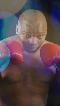 Vertical video: Male boxer shifting, causing feint and jab probing defense, bokeh over red gloves