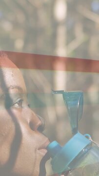 Vertical video: Runner lifting teal bottle and hydrating during fitness, band overlay crossing face