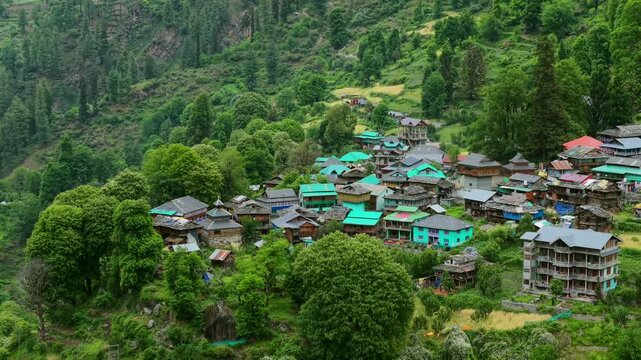 Aerial close up of Grahan village with traditional wooden houses with colorful roofs surrounded by dense greenery