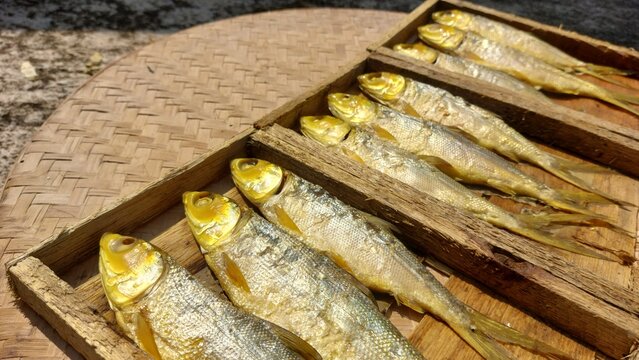 milkfish (bandeng) cooked using a pressure cooking method, making the bones soft and edible. The fish is neatly placed in a tray box, ready for sale in a traditional market setting. 