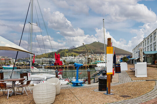 Waterfront Promenade Overlooking Signal Hill in Cape Town outdoor cafe seating, stationary telescope, and sailboats,