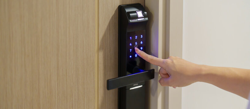 Hand press PIN number for smart digital door lock while open or close the door at home or apartment. NFC Technology, Fingerprint scan, keycard, smartphone and contactless lifestyle concepts