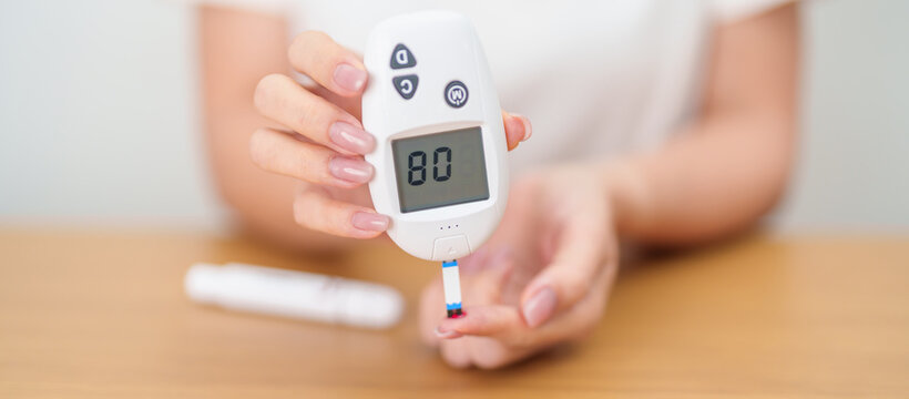 Hand checking Diabetes or Blood glucose self testing by digital blood glucose meter with lancet pen. high blood sugar level, World Diabetes Day, Glycemia, Hypoglycemia, Hyperglycemia and insulin
