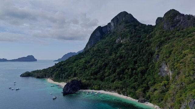 Cinematic drone flight from the ocean towards Papaya Beach. Dramatic view of the limestone coast before focusing on the white sand and turquoise water.