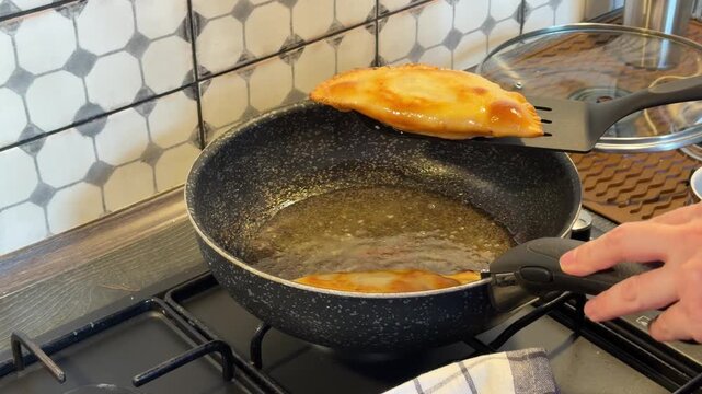 a fried cheburek is placed from the oil on a napkin