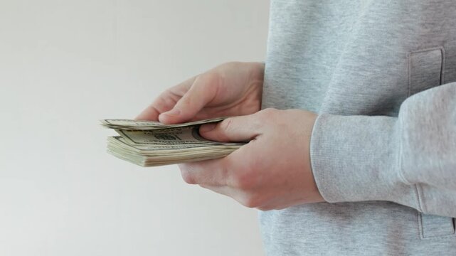 People counting stack of US dollar banknotes in hands, cash money close up