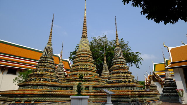 Ancient Buddhist pagodas with intricate porcelain mosaic design at Wat Pho, Temple of the Reclining Buddha, Bangkok, Thailand.