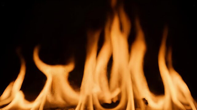 Vibrant tongues of orange and yellow fire dance rhythmically in the darkness, casting a warm glow and symbolizing both raw energy and potential danger